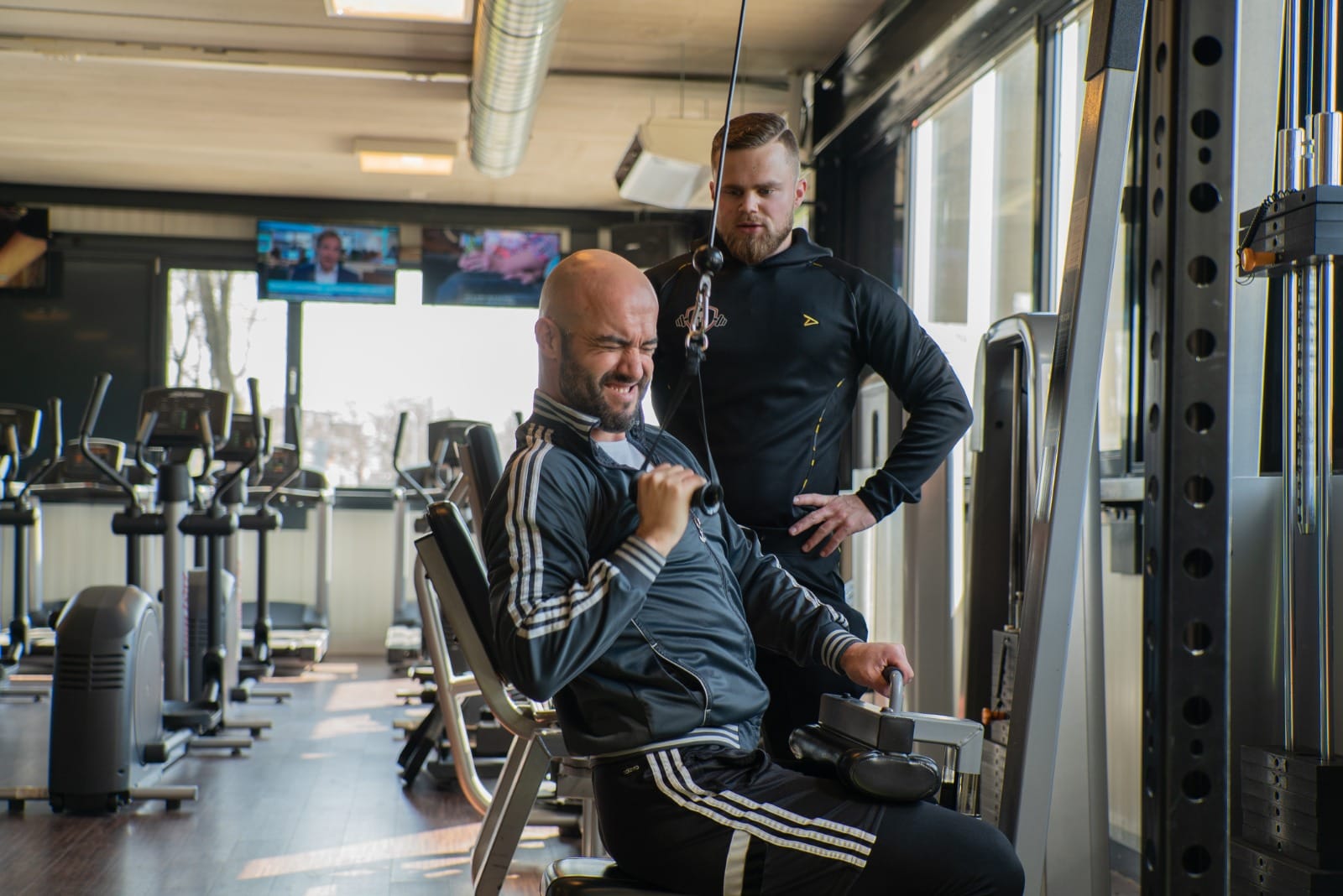 Simon geeft aanwijzingen bij een oefening met dumbbells